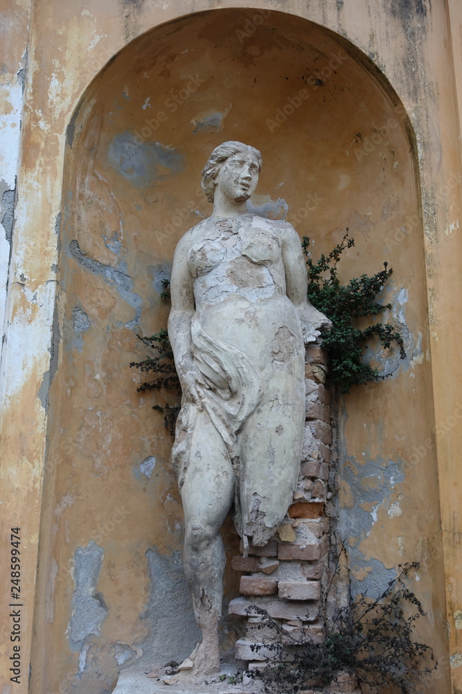 Abandoned feminine statue in a garden somewhere in Italy Abandoned feminine statue in a garden somewhere in Italy