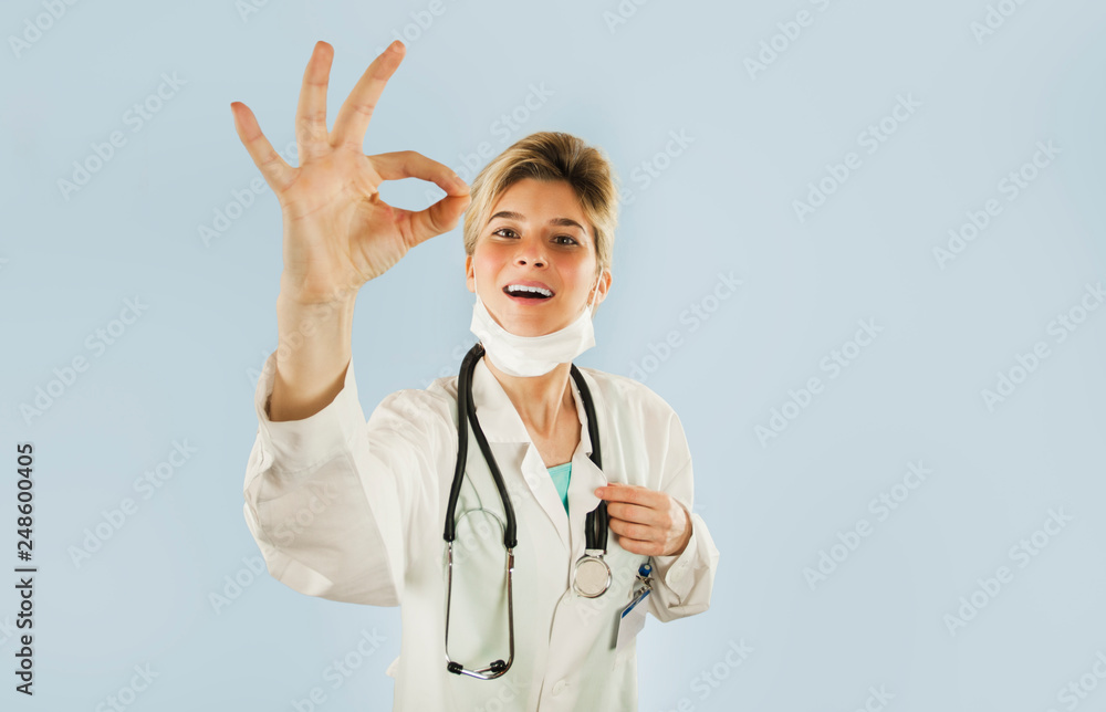 doctor girl shows thumb up on blue isolated background. Concept medicine and health doctor girl shows thumb up on blue isolated background. Concept medicine and health