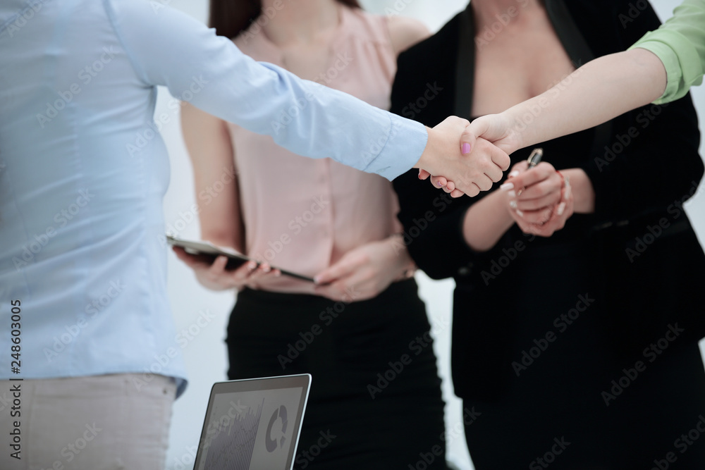 close up.handshake of business partners on background of employees
