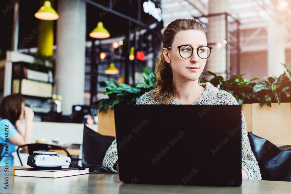 Happy caucasian woman millennial using laptop while sitting at cafe. Young businesswoman sitting in coffee shop, working on computer. Online marketing, business education for adult, teleworking. Happy caucasian woman millennial using laptop while sitting at cafe. Young businesswoman sitting in coffee shop, working on computer. Online marketing, business education for adult, teleworking.