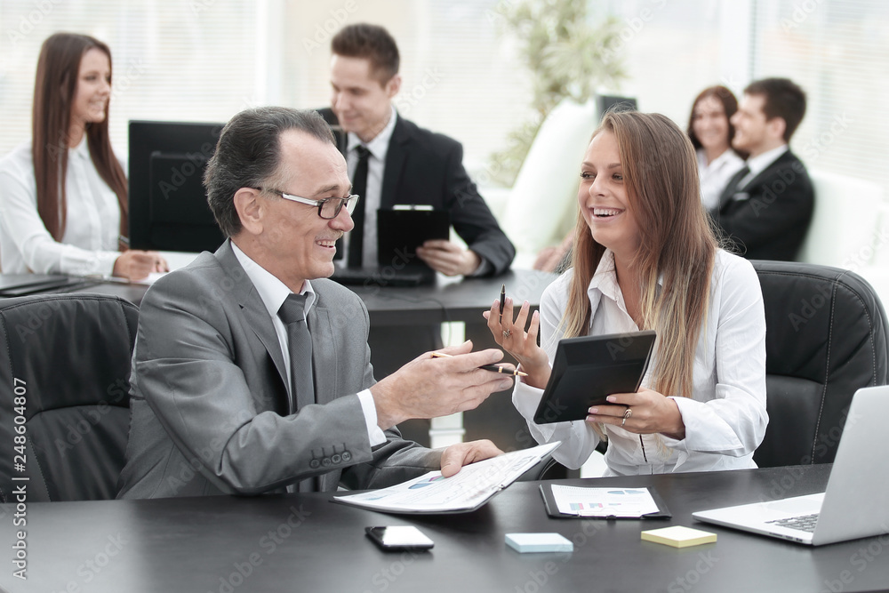 businessman and the assistant laughing while sitting at workplace in office. businessman and the assistant laughing while sitting at workplace in office.