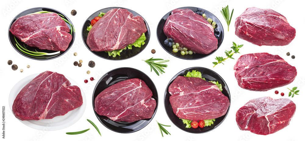 Piece of raw beef on black plate isolated on white background, collection, with spices and herbs Piece of raw beef on black plate isolated on white background, collection, with spices and herbs