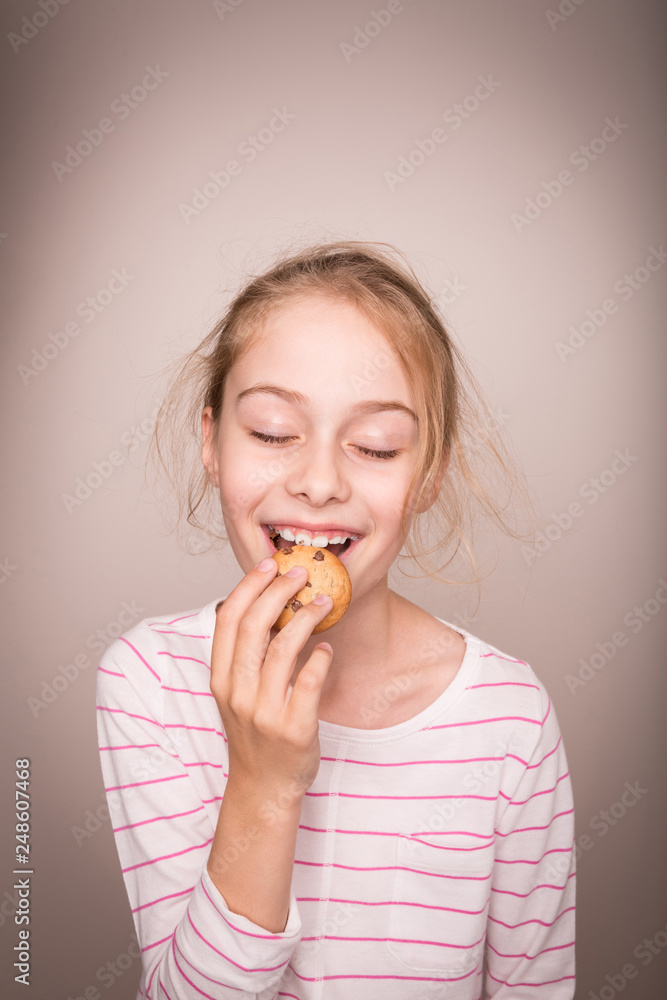 Happy blond caucasian child girl eating cookie. Happy blond caucasian child girl eating cookie.