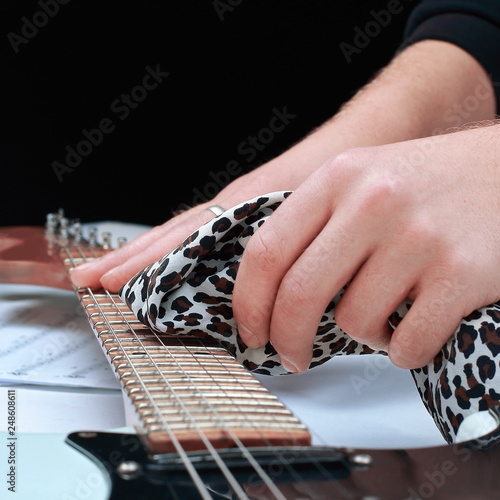 closeup.rock guitarist,wiping the neck of the guitar