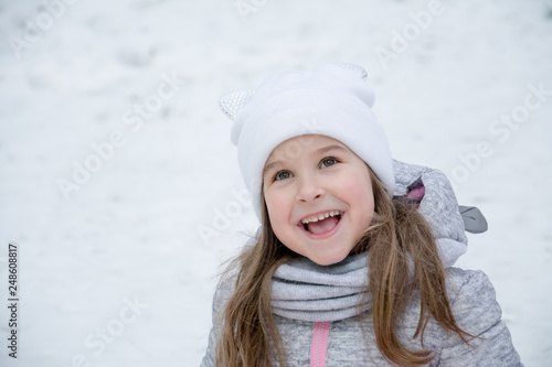 portrait of a beautiful little girl of 6 years in the winter park