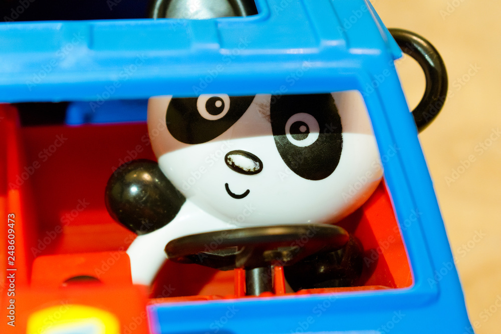 Obraz premium Toy plastic panda driving a car