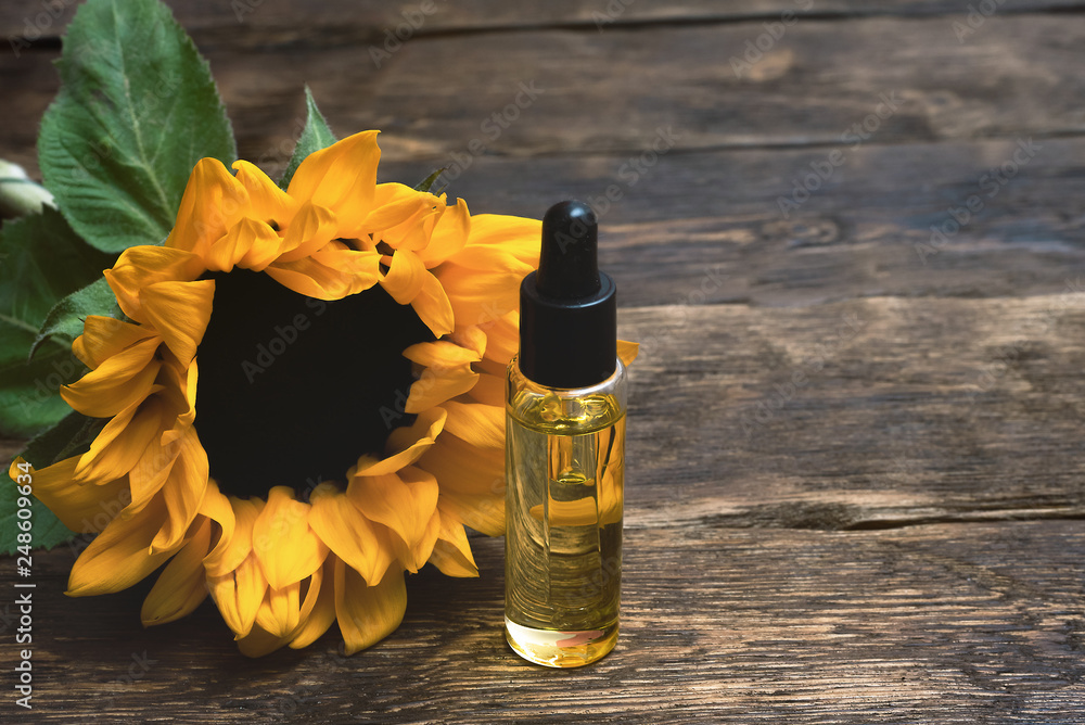 Sunflower oil in the bottle on the wooden table background. Sunflower oil in the bottle on the wooden table background.