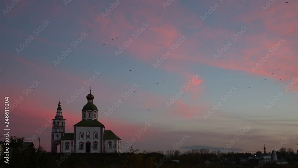 Flock of birds over the Ilinsky church in Suzdal at sunrise, Golden Ring of Russia.The sound - the cries of birds Flock of birds over the Ilinsky church in Suzdal at sunrise, Golden Ring of Russia.The sound - the cries of birds