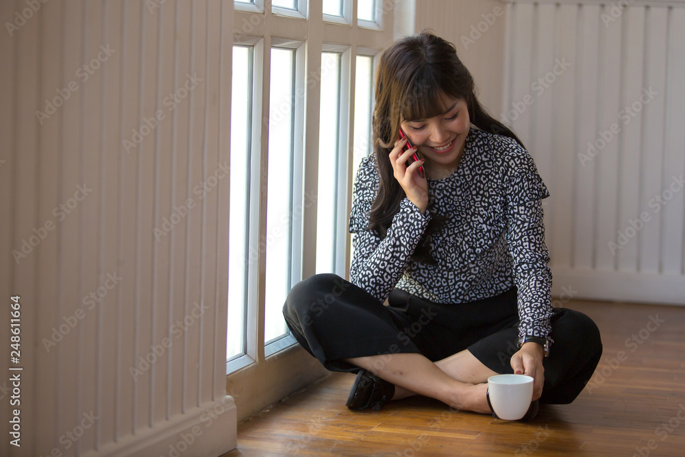 Woman holding phone while relaxing at home Woman holding phone while relaxing at home