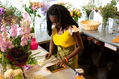 Obraz na plátně Attentive young gardener working at floral boutique