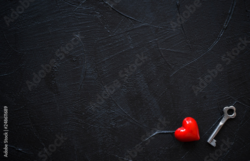 Red heart with vintage key on black background.Copy space.Valentines Day concept.Top view