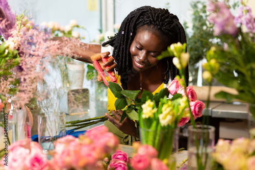 Fotografija Beautiful international florist taking care of flowers