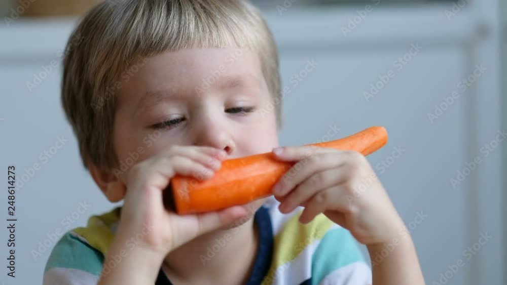Happy little boy holding a carrots. Concept of healthy food. Close up Happy little boy holding a carrots. Concept of healthy food. Close up