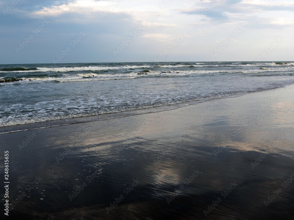 Clouds are reflected in surf waves, Rimini,  Italy, Adriatic sea.