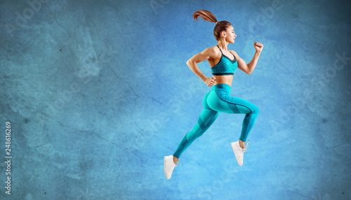 Young woman runner in turquoise sportswear jump in the air.