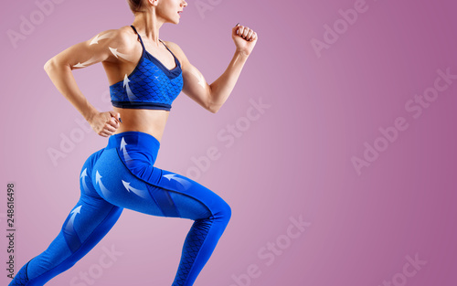 Fototapeta Naklejka Na Ścianę i Meble -  Young woman runner in blue sportswear jump in the air.