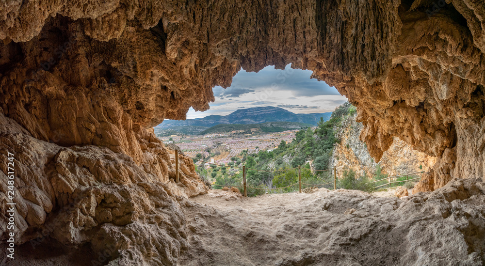 Almond tree in blossom valley from inside of the cave