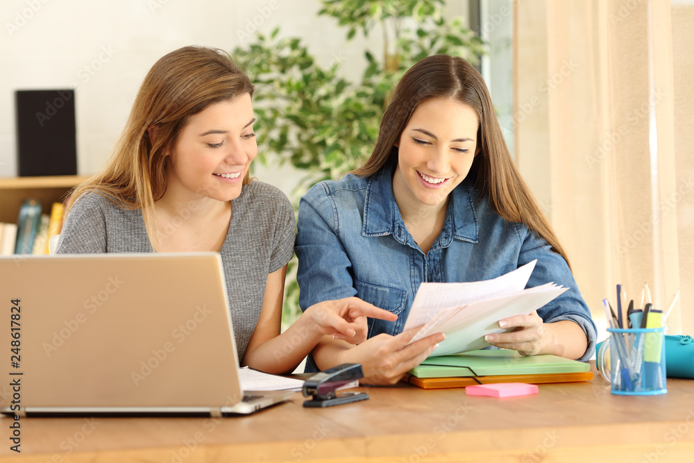 Happy students studying checking notes at home Happy students studying checking notes at home