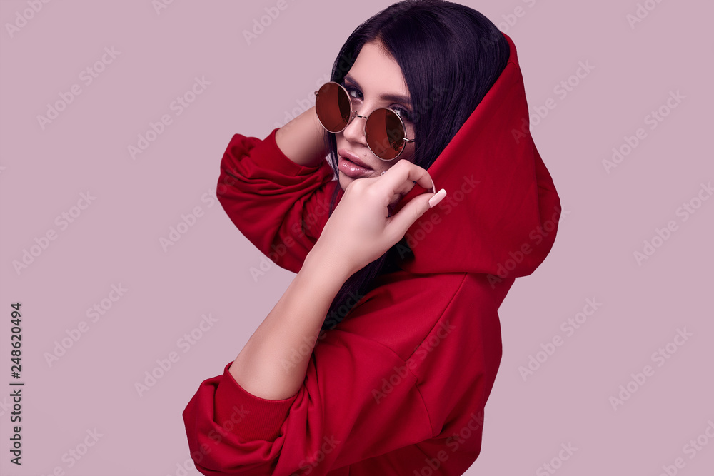 Obraz premium Gorgeous brunette woman in fashion red hoodie in studio