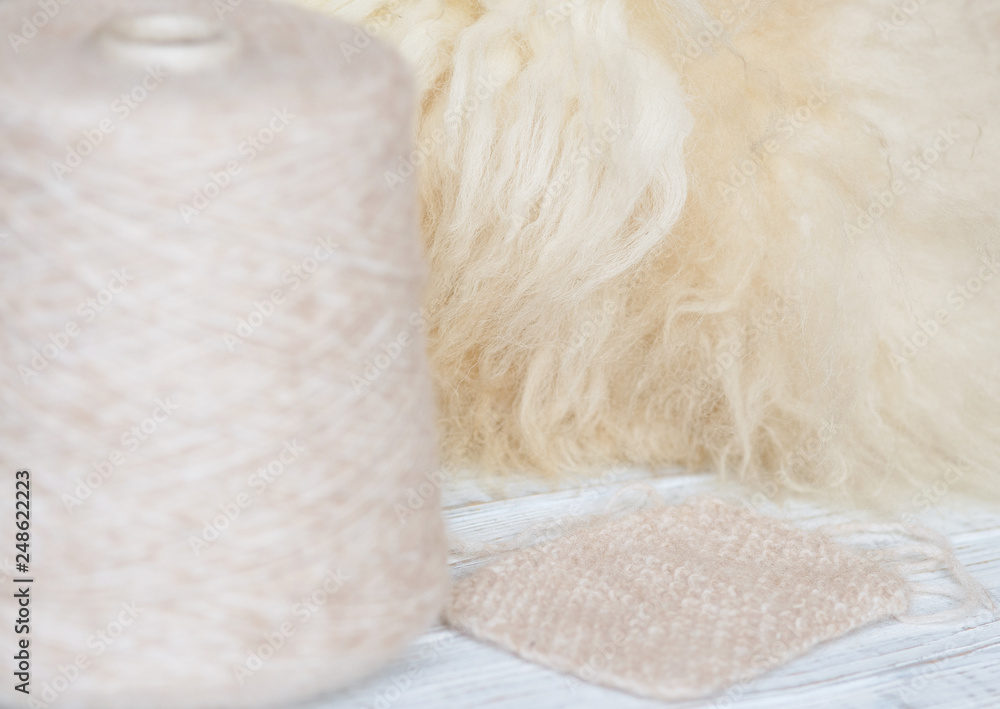 Skein of natural threads on the background of fur Skein of natural threads on the background of fur