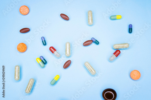 Different pills on a blue background. A photo of different medical drugs, tablets and pills on blue background Pretty pills.