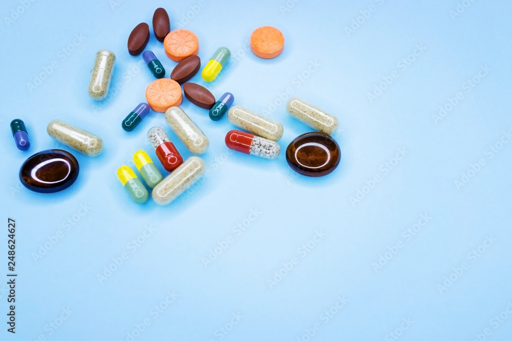 Different pills on a blue background. A photo of different medical drugs, tablets and pills on blue background Pretty pills. Different pills on a blue background. A photo of different medical drugs, tablets and pills on blue background Pretty pills.