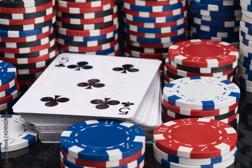 deck of playing cards surrounded by stacks of poker chips background