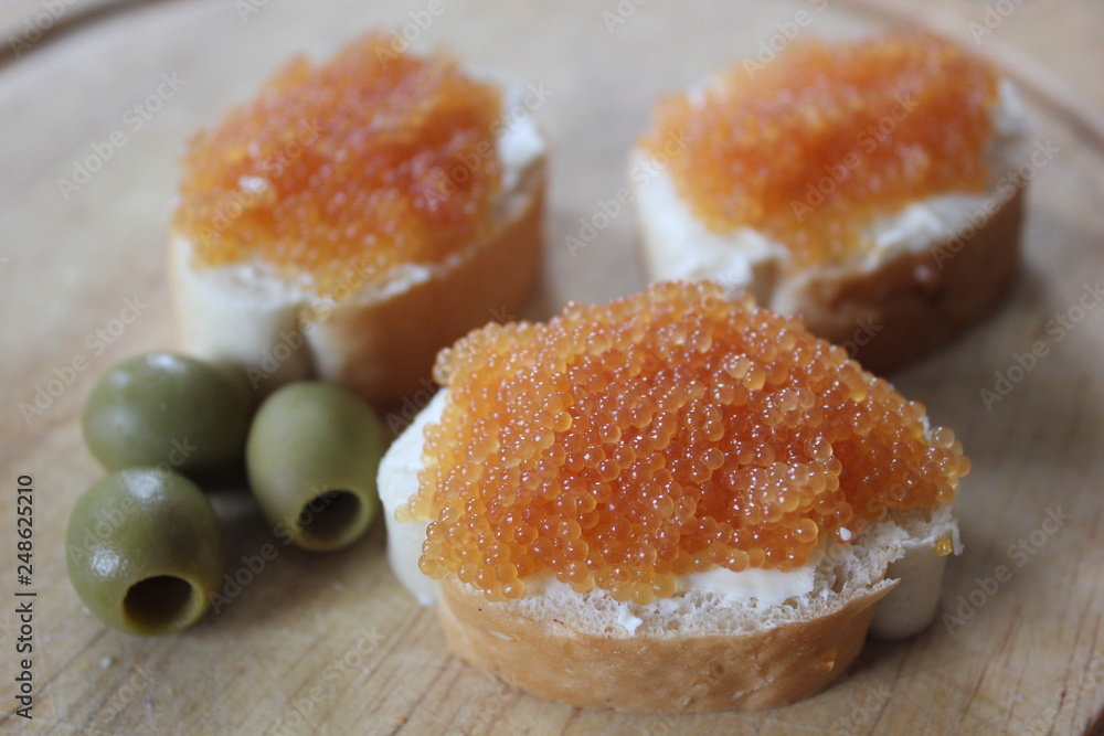 Golden pike caviar on white bread with olives Golden pike caviar on white bread with olives