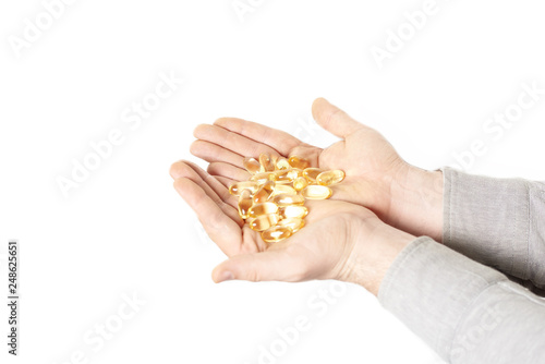 pills in male hand closeup on white background