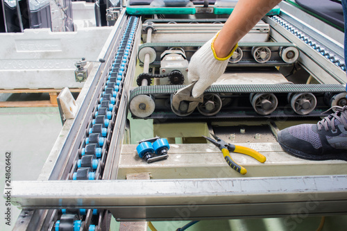 worker maintenance and repair conveyor belt in factory