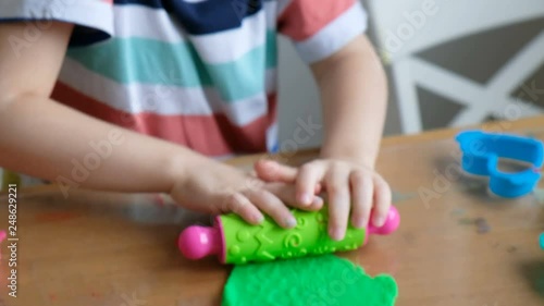 Lovely 4 years boy with playdough at home. Hands close up photo