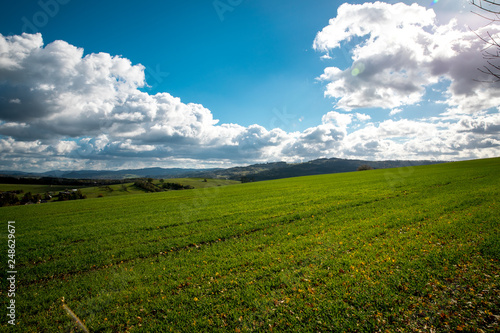 A view of the hill called Helfštýn on the field and the surrounding can be seen village Krhová during a sunny day with many colored clouds