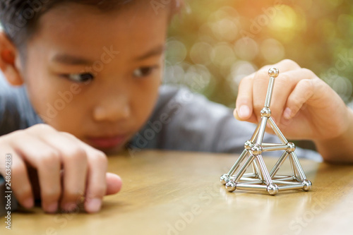 Young boy play a  stick and magnetic ball