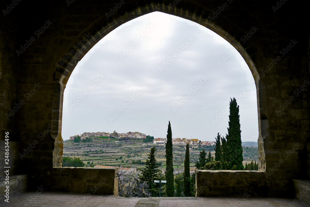 Horta de Sant Joan, Catalonia / Spain - March 22, 2010: Skyline of the village in the top of a hill seen through an arch of  Sant Salvador Church