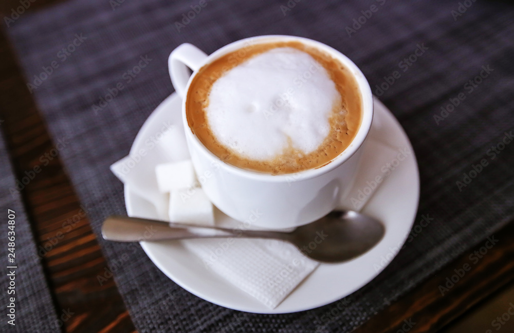 Cappuccino in a white cup. Fresh morning aromatic breakfast.