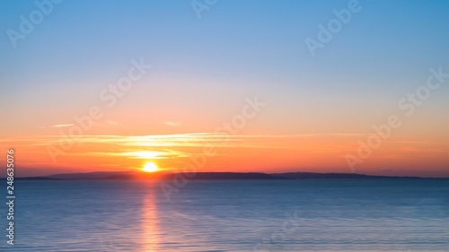 Long Exposure Sunrise over a Blue Sea with Silky Smooth Water