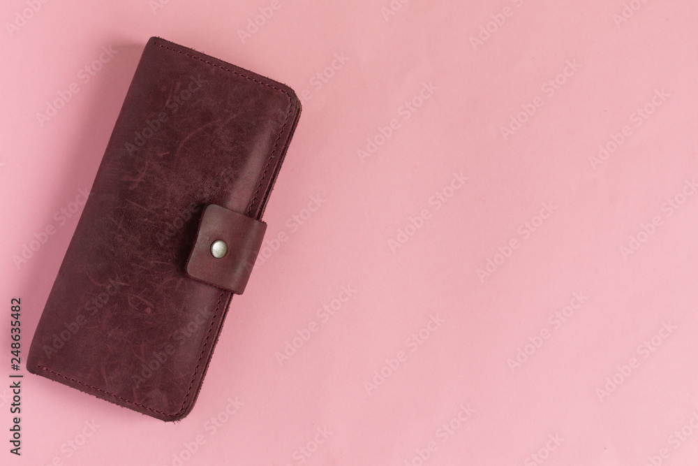Female wine-colored wallet on pastel pink background. Flat lay. Copy space. - obrazy, fototapety, plakaty 