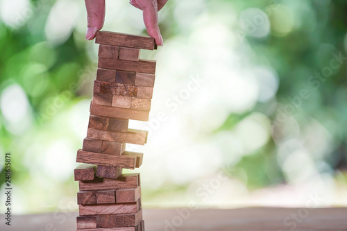 Planning, risk and strategy in business, businessman and engineer gambling placing wooden block on a tower.
