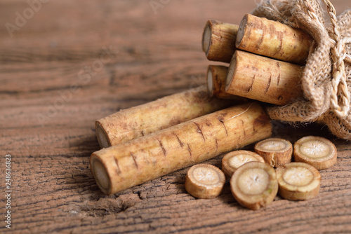 Foto fresh burdock root or Gobo in sack and on wooden background