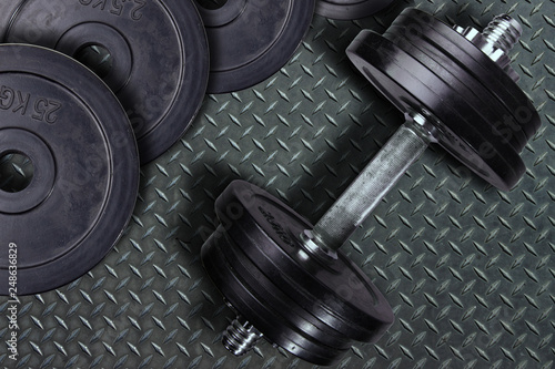 Dumbbell and weights on a wooden background.
