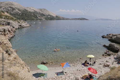 Mediterranean landscape during the summer. View of the beautiful, wild beach. Pleasant, quiet, calm bay, gulf. Hot, sunny day. Transparent, pure water in Adriatic Sea. Old Baska, Krk island, Croatia