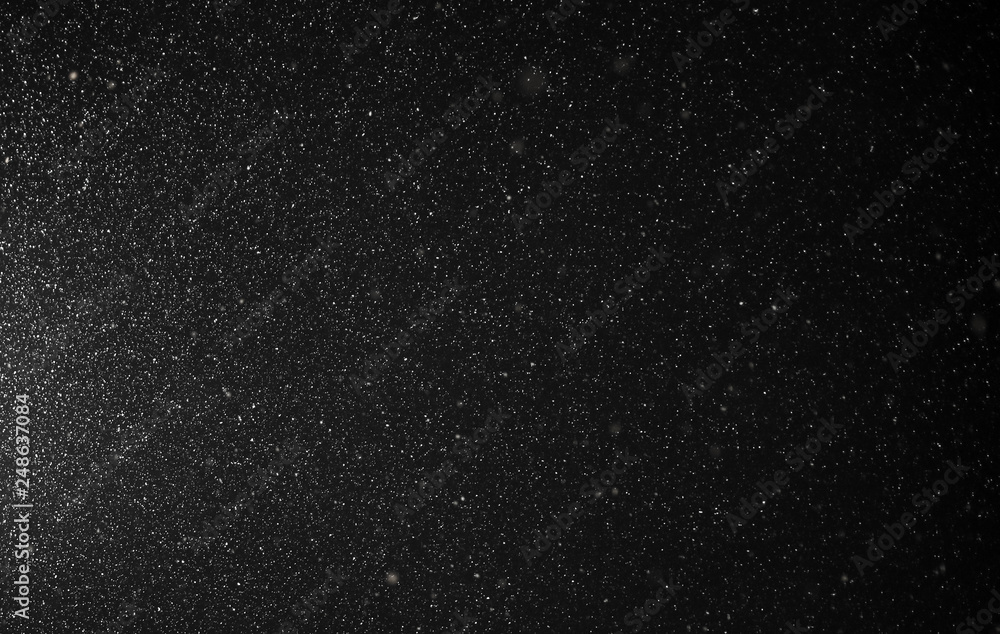 Snow flies in the sky at night as a background