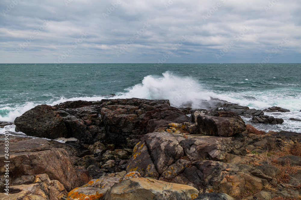 sea ​​scenery in dramatic weather in the blue hour. a landscape with dramatic clouds and stormy water that breaks down on the shore and the rocks.