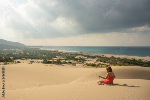 Girl in red relaxing in sandy desert