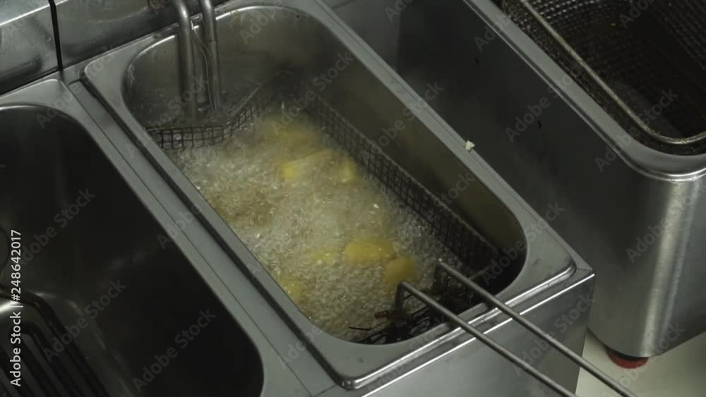 Fast food potato pieces are fried in sunflower oil in restaurant Deep