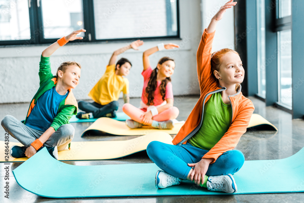Happy kids stretching on fitness mats with smile - obrazy, fototapety, plakaty 
