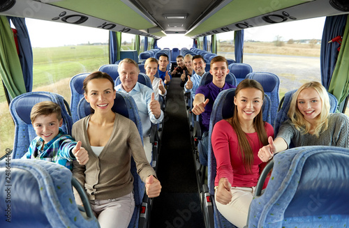 transport, tourism and travel concept - group of happy passengers travelling by bus and showing thumbs up