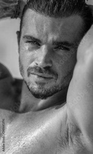 Vertical portrait of a handsome caucasian male model posing on the beach