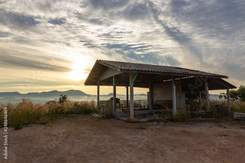 Old abandoned house at the mountain over sunrise in the morning fog.