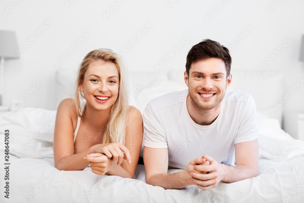 love, relationships and people concept - happy couple lying in bed at home love, relationships and people concept - happy couple lying in bed at home